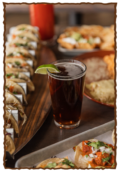 Beer amongst tacos and mexican food